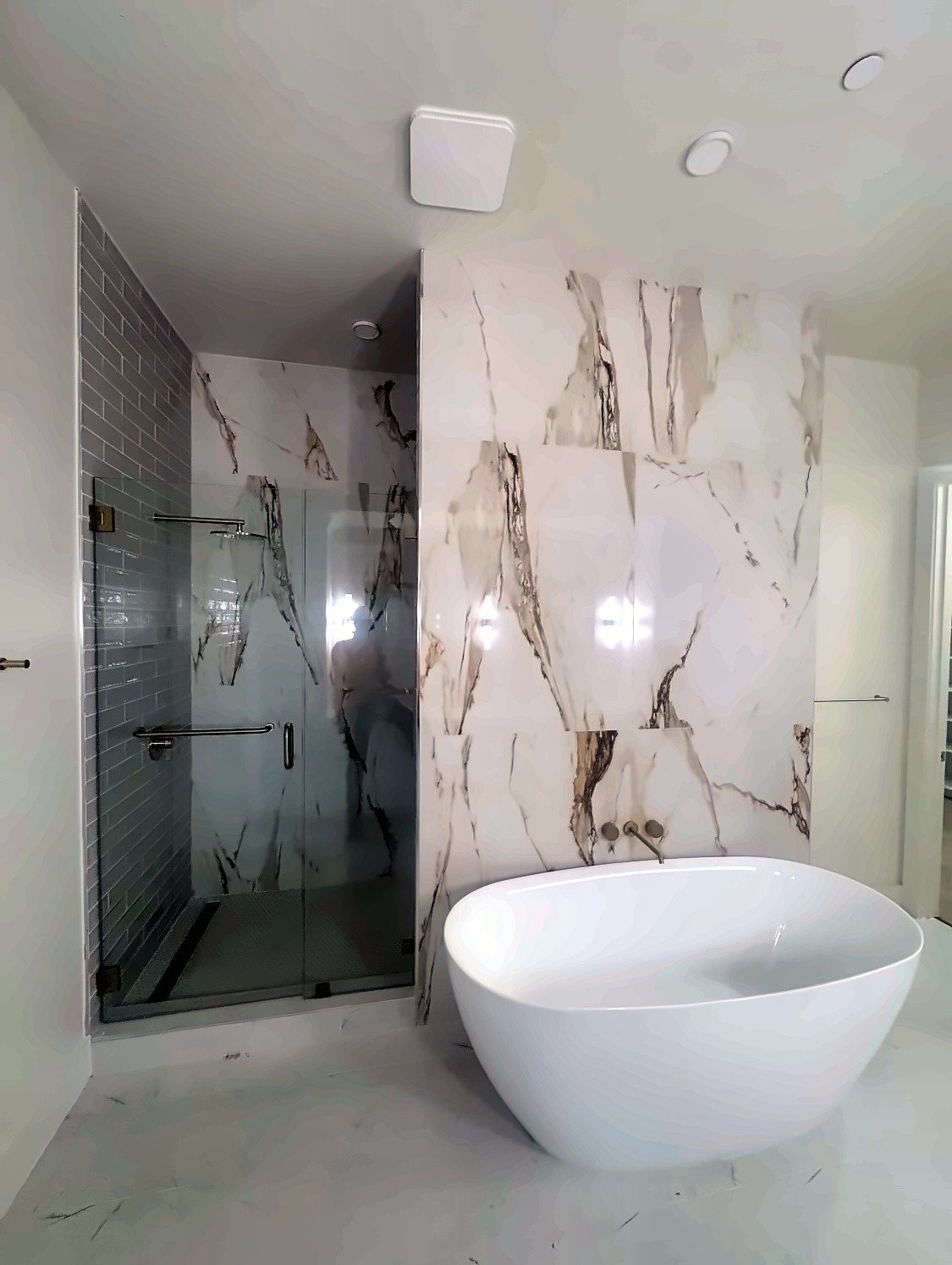 Freestanding tub in front of a large-format porcelain wall