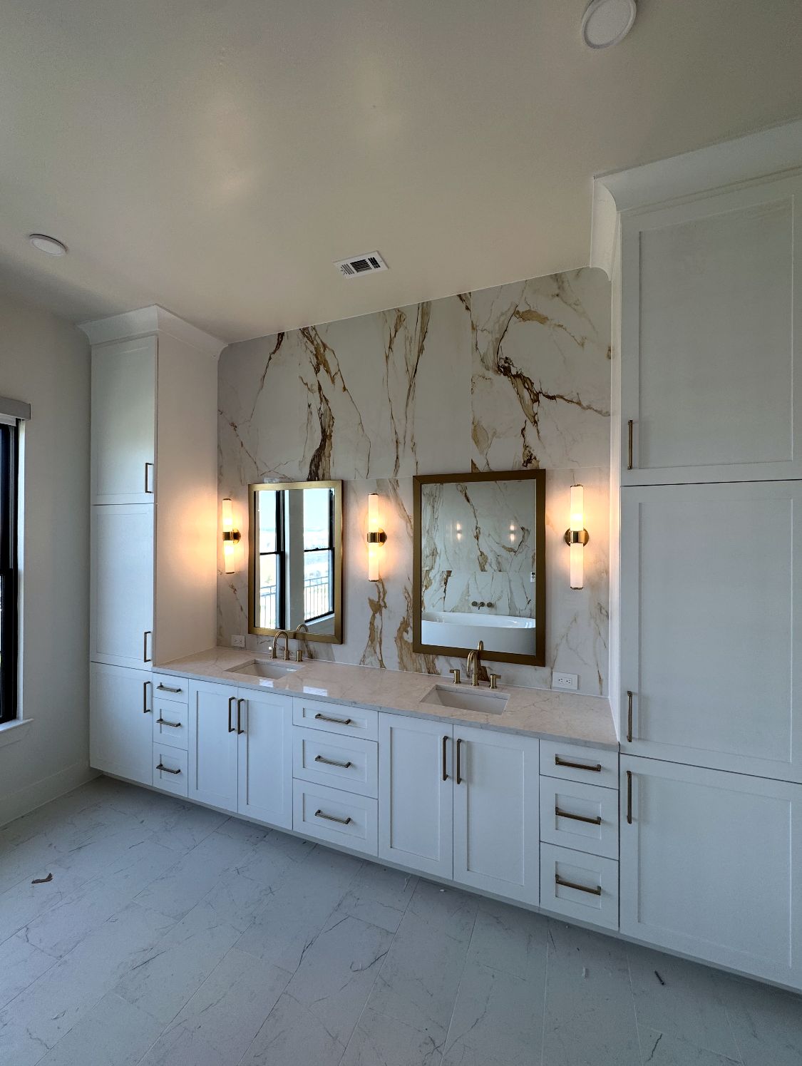 Primary bath with a double vanity against a large-format porcelain wall